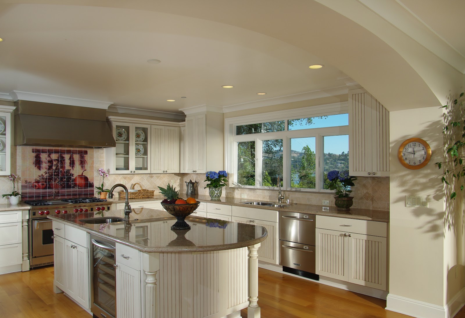 Interior kitchen with white cabinetry, stainless appliances, island seating, and panoramic window overlooking water
