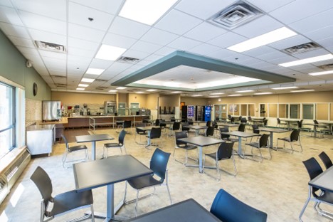 Interior multipurpose room with educational tables and chairs arranged for group activities and therapeutic sessions