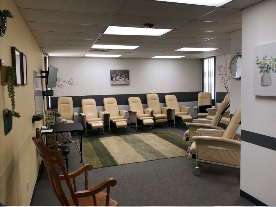 Interior therapy space with multiple beige recliners arranged in rows, light colored walls, and comfortable seating configuration for group sessions