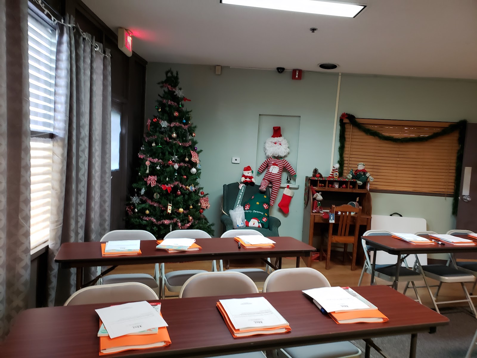 Interior therapy space with tables, chairs arranged for group sessions, holiday decorations, and access to additional rooms
