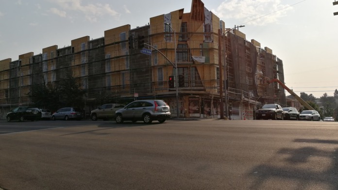 Exterior view of large vintage brick building with multiple stories and street-level parking