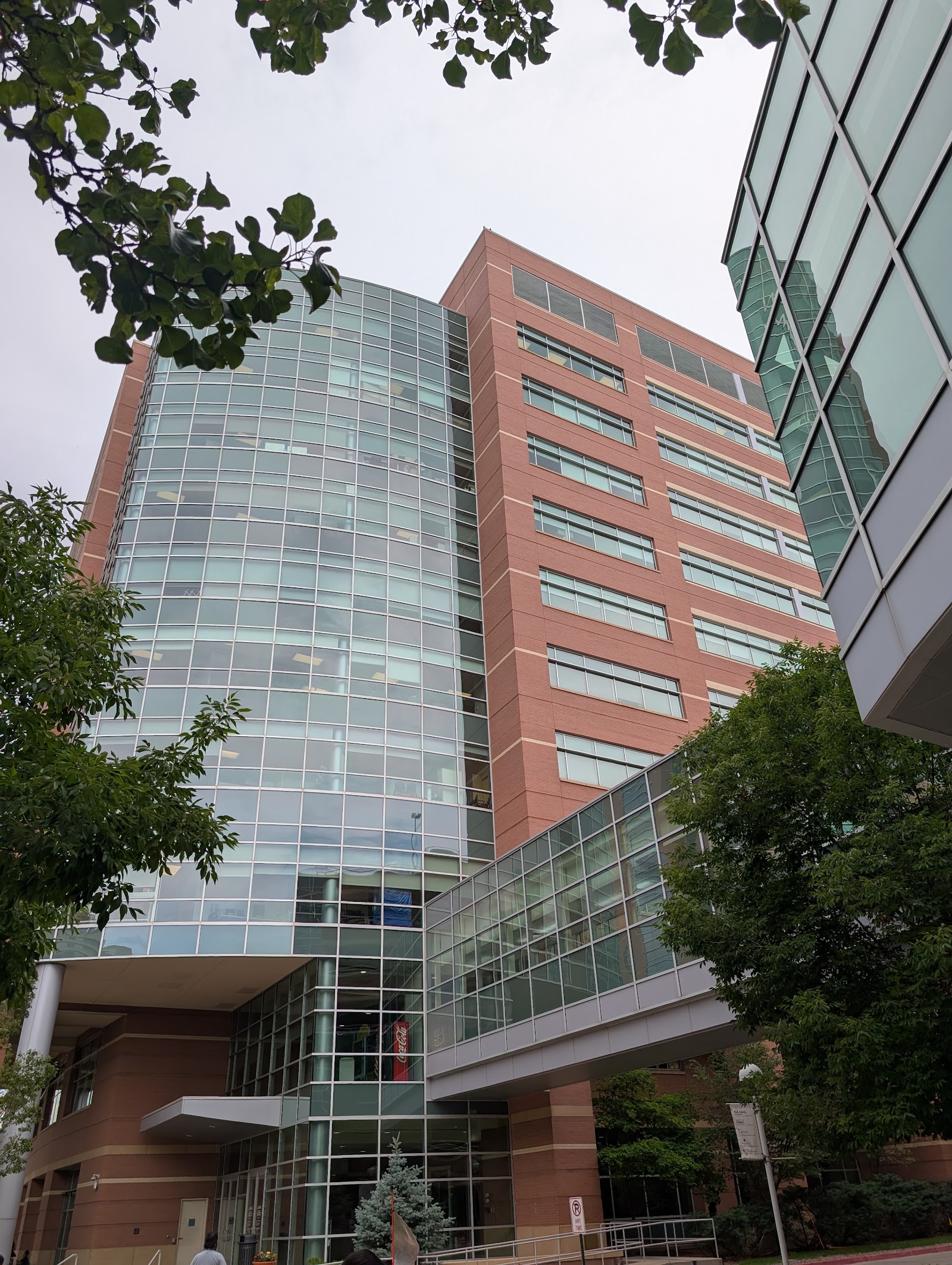 Exterior of multi-story hospital building with red brick and glass curtain wall construction