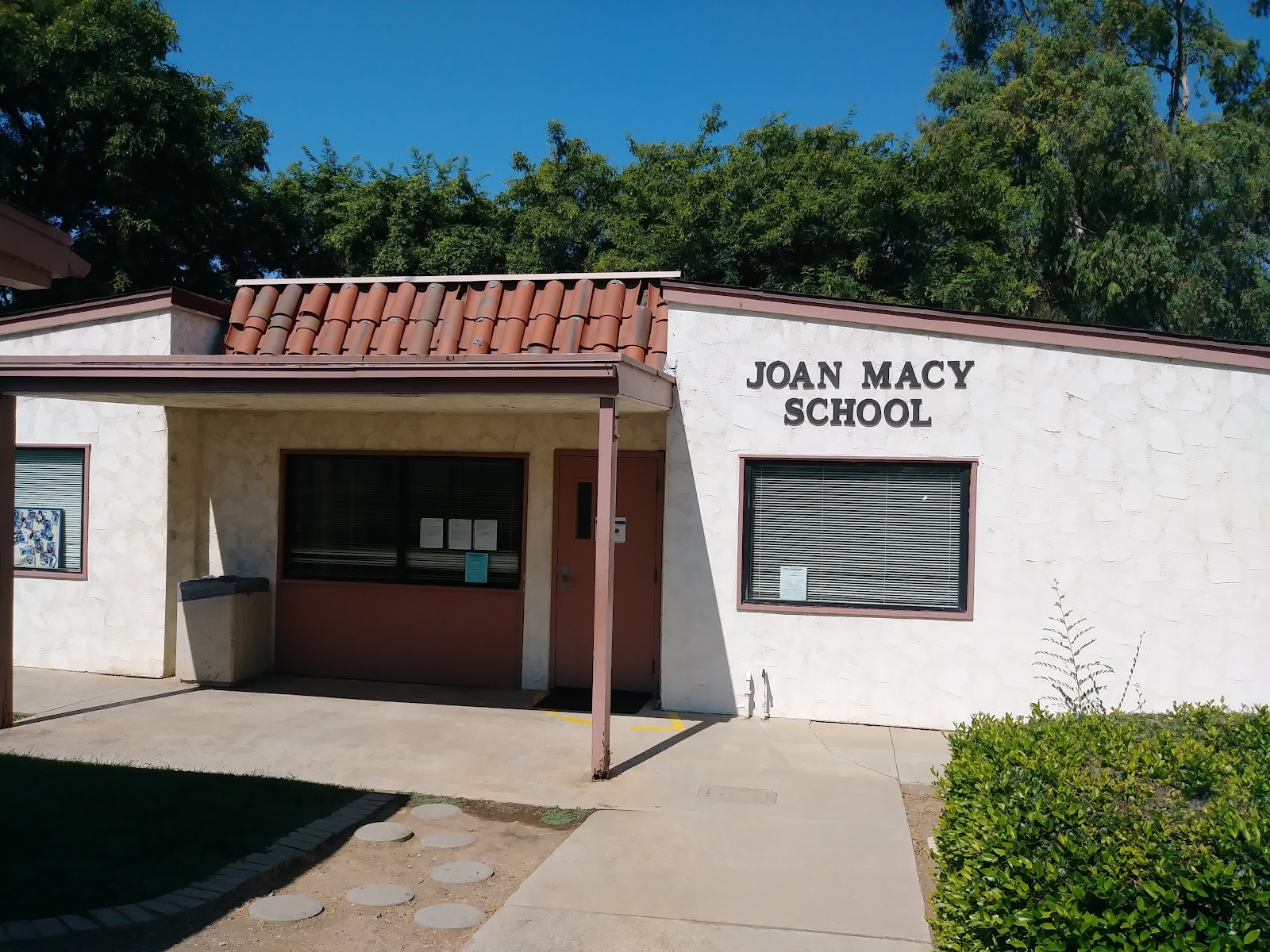 Educational facility with terra-cotta tile roof, entry portal, window, and concrete entrance