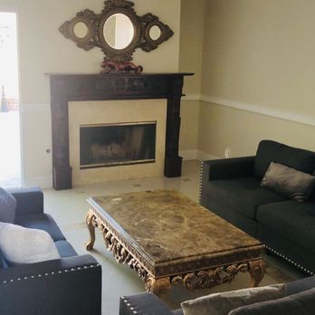 Interior living room with black fireplace, ornate mirror, dark furniture, and decorative coffee table