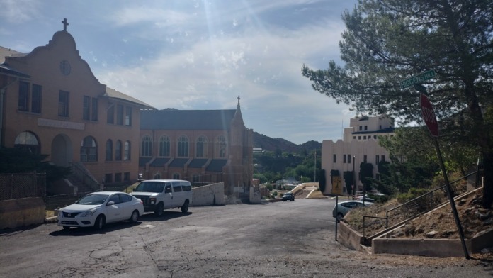 Exterior view of treatment facility showing multi-story buildings, parking area, and surrounding mountainous landscape.
