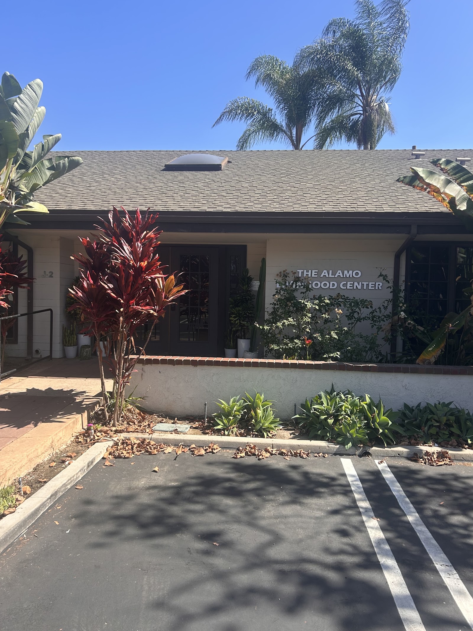Exterior view of single-story treatment facility with beige stucco, landscaping, parking area, and signage.