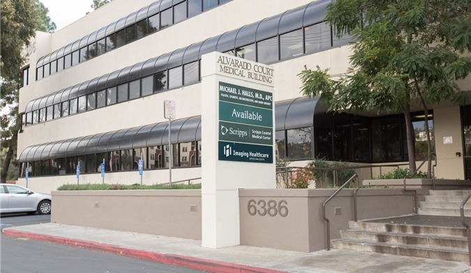 Exterior view of multi-story beige treatment facility building with entrance, landscaping, and address signage at 6386 Alvarado Court