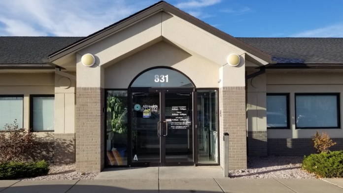 Exterior view of AllHealth Network Castle Rock treatment center showing main entrance with signage, brick facade, and landscaping