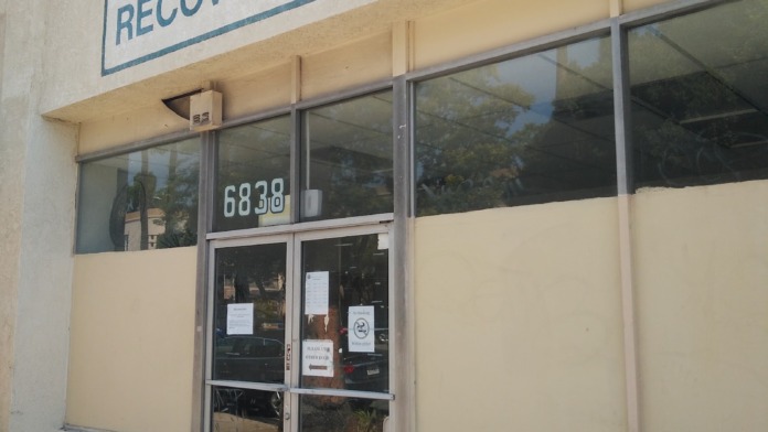 Exterior view of BHS Hollywood Recovery Center entrance at 6838 West Sunset Boulevard with blue facility signage and glass doors