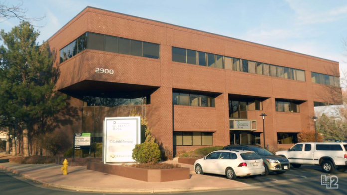 Exterior of brick treatment facility building with entrance, parking area, and landscaping visible