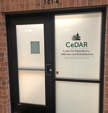 Exterior entrance showing facility unit number 101-A and CeDAR Center branding on glass door and window display
