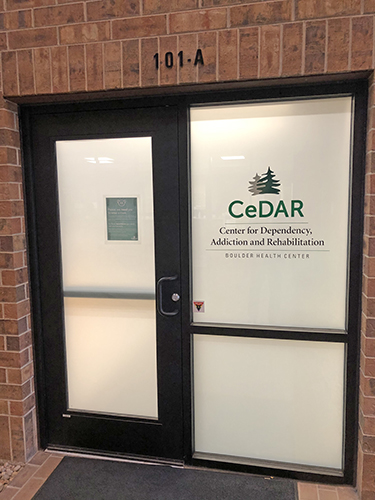 Exterior entrance showing facility unit number 101-A and CeDAR Center branding on glass door and window display