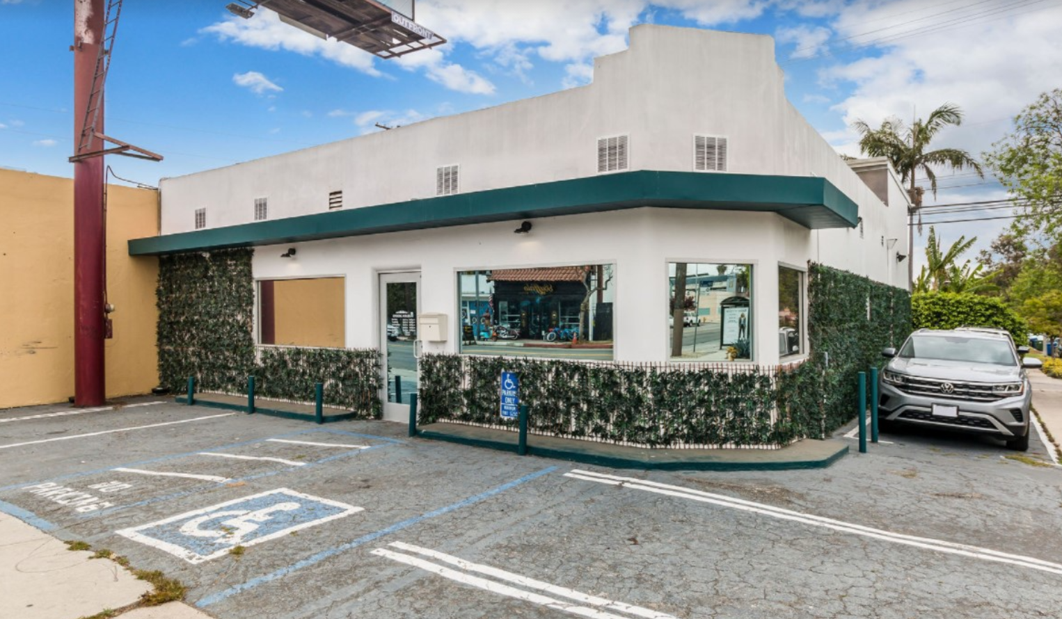 Exterior front facade of treatment center with white building, teal trim, landscaping, accessible parking, and entrance