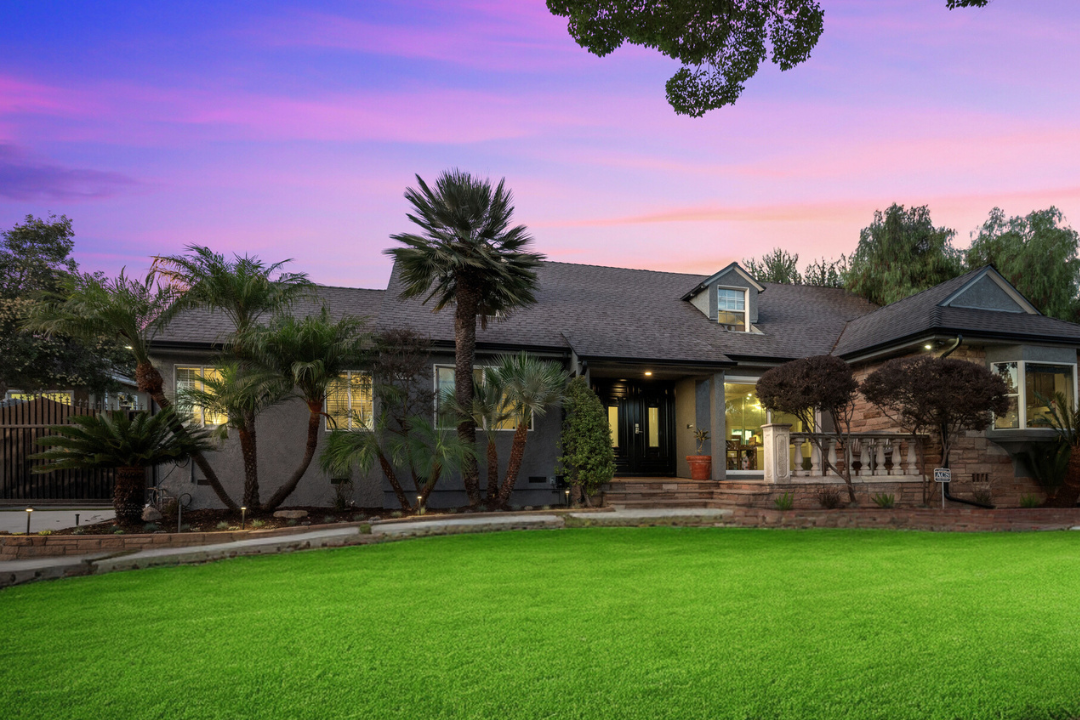 Exterior view of residential treatment facility with manicured lawn, palm trees, and contemporary architecture at sunset