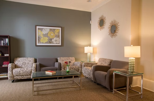 Interior lounge featuring gray and brown furniture, accent walls, wall art, and modern lighting fixtures