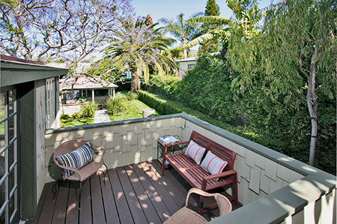 Outdoor deck with lounge chairs, cushioned seating, trees, and natural landscape surroundings