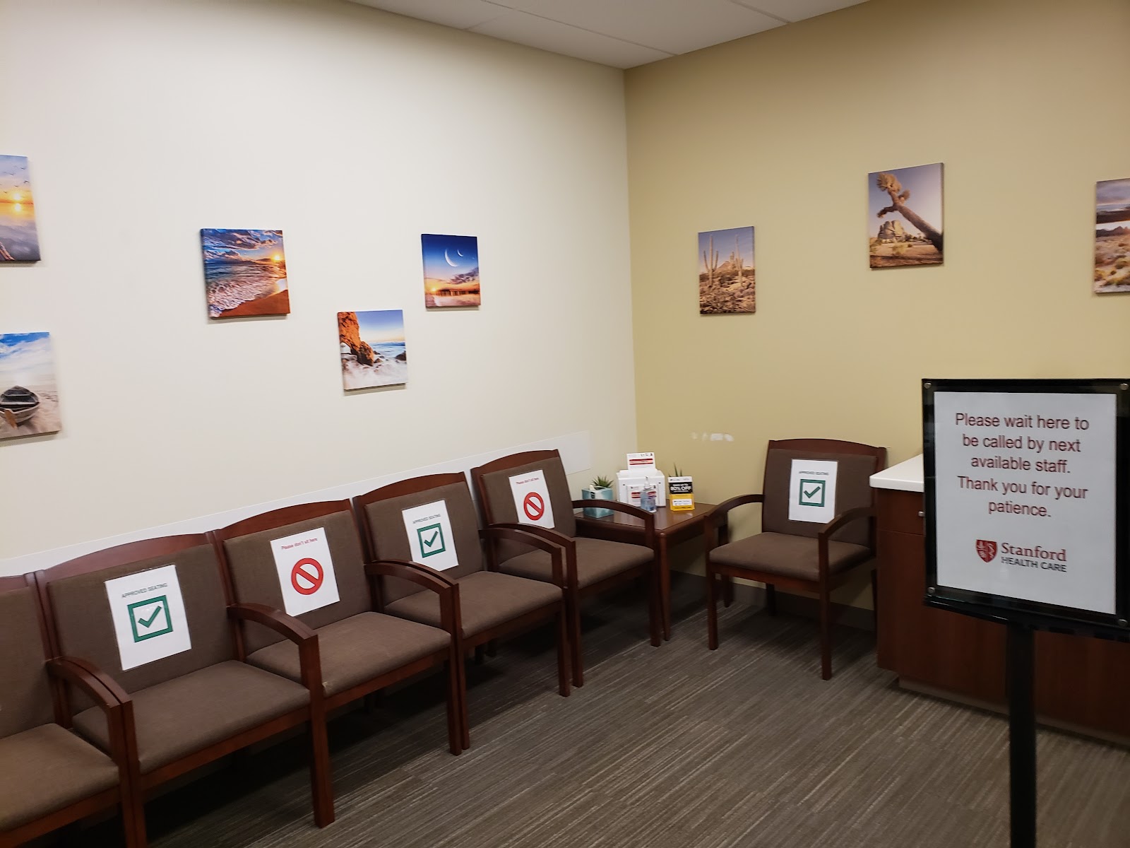 Interior waiting room with wooden chairs, calming artwork on walls, and informational signage displayed
