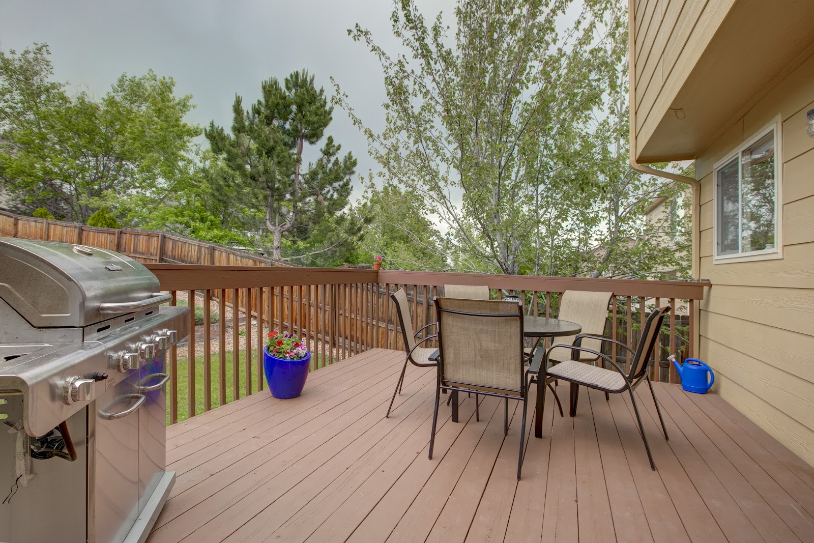 Outdoor picnic area with table, concrete pad, surrounding lawn, and natural tree coverage
