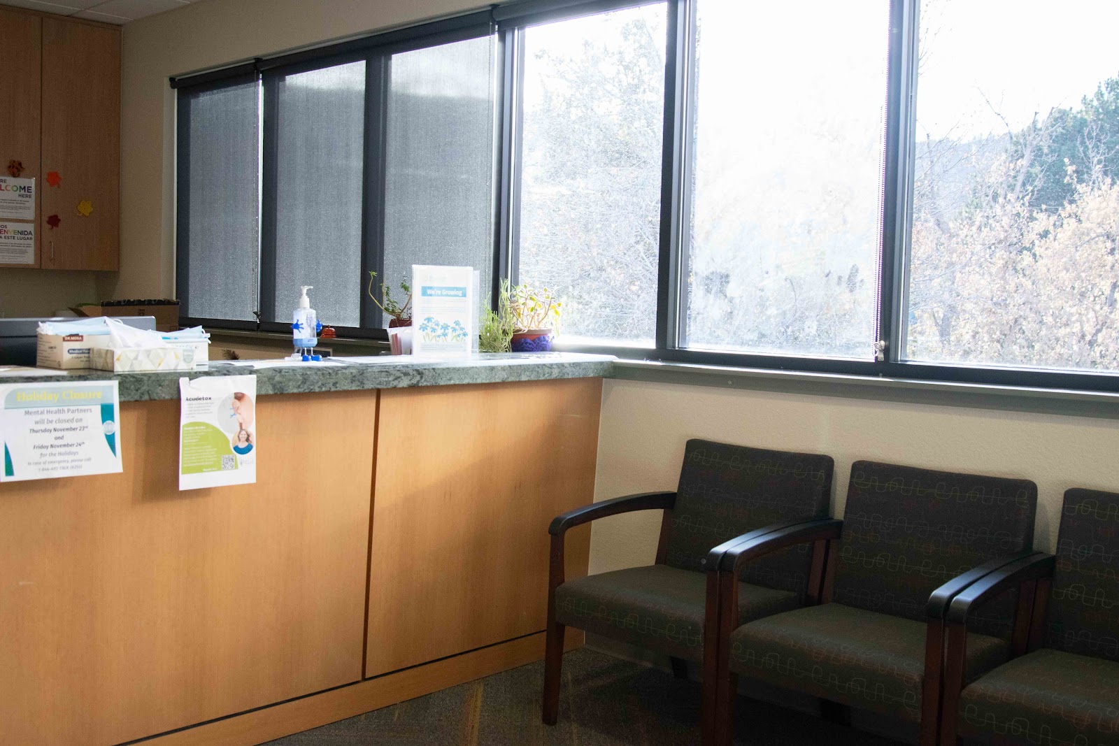 Interior reception counter with office seating, large windows, mountain views, and informational materials
