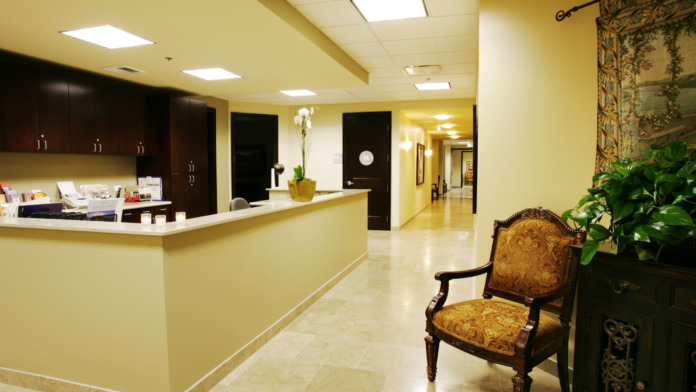 Interior reception area with yellow walls, dark cabinetry, and comfortable seating with decorative furnishings