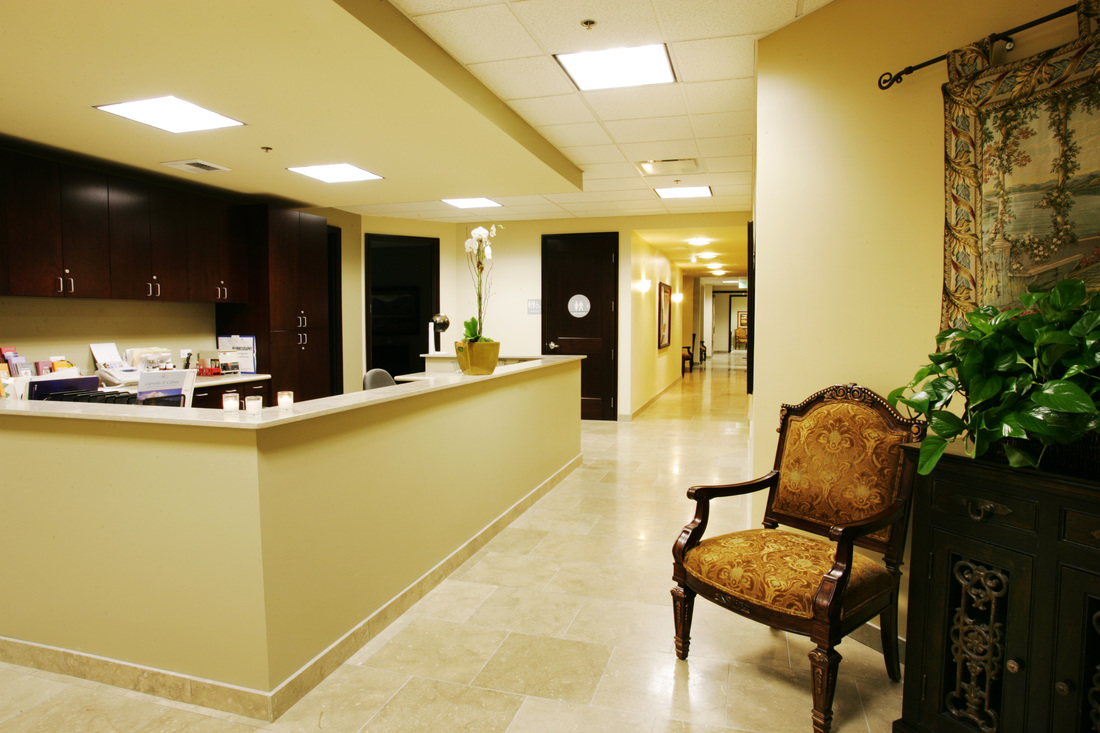 Interior reception area with yellow walls, dark cabinetry, and comfortable seating with decorative furnishings