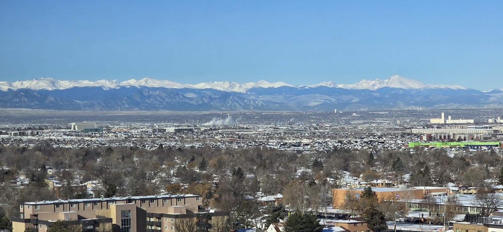 Panoramic view of Denver metro area with Rocky Mountains in background and residential neighborhoods