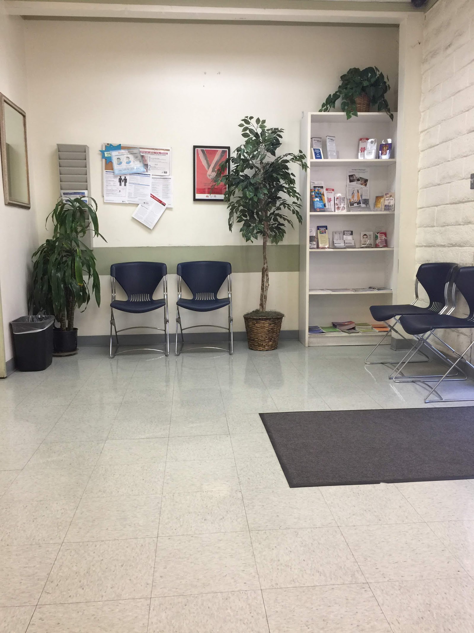 Interior seating space with chairs, three-panel artwork, bulletin board, and wall decor