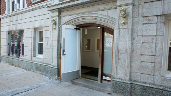Exterior view of treatment center entrance on street level showing stone facade, arched doorway, and ground floor access