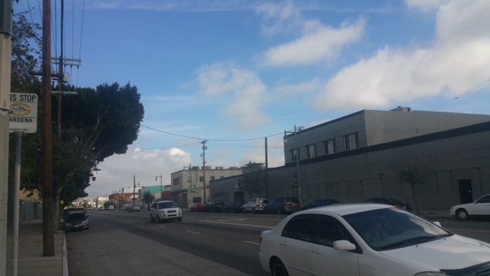 Exterior view of multi-story industrial building on Main Street with parking area and street signage