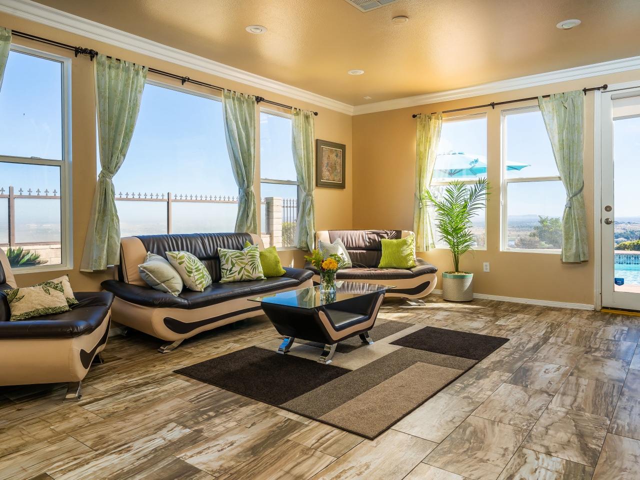 Interior lounge area with multiple seating arrangements, large windows with scenic landscape views, and plants